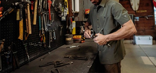 A man in his workshop working at his workbench 